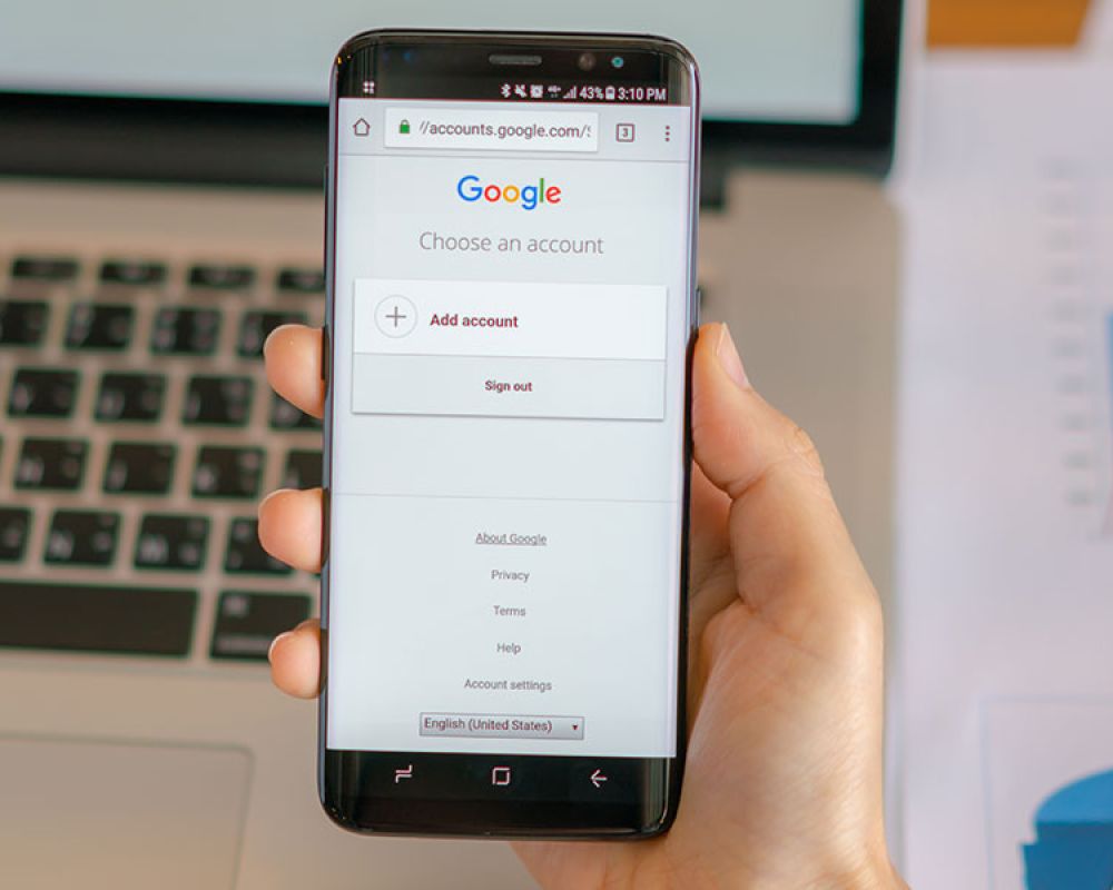 Smartphone mit Google-Anmeldebildschirm vor einem Laptop, repräsentiert die Nutzung von Google-Diensten auf mobilen Geräten. Smartphone mit Google-Anmeldebildschirm vor einem Laptop, repräsentiert die Nutzung von Google-Diensten auf mobilen Geräten.