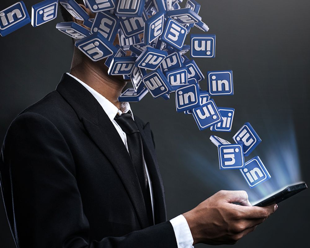 Geschäftsmann mit LinkedIn-Logos, die aus seinem Kopf fließen, symbolisiert intensives LinkedIn-Marketing.