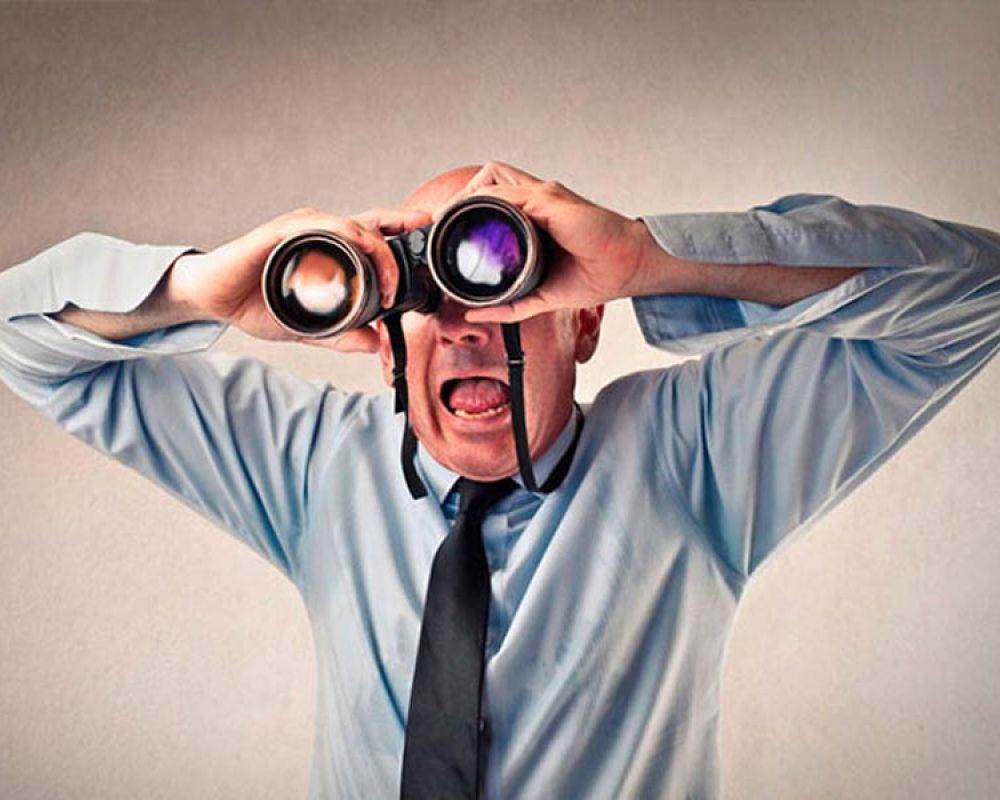 Mann mit Fernglas, symbolisiert Marktbeobachtung und Wettbewerbsanalyse durch eine Marketingagentur. Mann mit Fernglas, symbolisiert Marktbeobachtung und Wettbewerbsanalyse durch eine Marketingagentur.