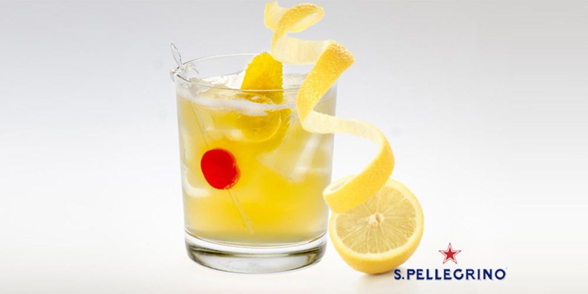 Cocktail mit Zitronenzeste und Kirsche, präsentiert in einem Glas, aufgenommen bei einem Fotoshooting für S.Pellegrino durch unsere Marketingagentur.